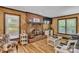 Cozy living room with wood paneled walls, brick fireplace, and lots of natural light at 408 Camelot Dr, Salisbury, NC 28144