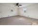 Bright bedroom with neutral carpeting, two windows for natural light, and a ceiling fan for comfort at 411 S Central Ave, Landis, NC 28088