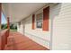 Inviting front porch with red painted wood and white siding, offering a cozy outdoor space at 411 S Central Ave, Landis, NC 28088