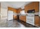 Functional kitchen with wooden cabinets, white appliances, and easy-to-clean tiled floor at 411 S Central Ave, Landis, NC 28088