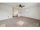 Comfortable living room with ceiling fan, carpet and entry featuring decorative door at 411 S Central Ave, Landis, NC 28088