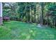 Large backyard with lush lawn and mature trees leads to a private wooded area at 5437 Mallard Ln, Gastonia, NC 28052