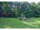 Spacious backyard features a large lawn with mature trees and garden beds at 5437 Mallard Ln, Gastonia, NC 28052