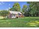 Lush backyard with ample space, highlighted by a charming brick home, perfect for outdoor living and enjoying serene surroundings at 5476 Twelve Oak Ln, Conover, NC 28613
