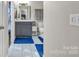 Bathroom with gray vanity, white toilet, white floor tiles and blue rugs at 5476 Twelve Oak Ln, Conover, NC 28613