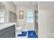 Bathroom with gray vanity, white toilet, white floor tiles, blue rugs and glass enclosed shower at 5476 Twelve Oak Ln, Conover, NC 28613