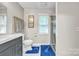 Bathroom with gray vanity, white toilet, white floor tiles, blue rugs and glass enclosed shower at 5476 Twelve Oak Ln, Conover, NC 28613