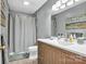 Bathroom with wood vanity, gray walls, gray shower curtain and wood look floors at 5476 Twelve Oak Ln, Conover, NC 28613