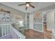 Cozy Bedroom with sage walls, white trim, wood floors, ceiling fan and white crib at 5476 Twelve Oak Ln, Conover, NC 28613