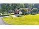 Charming brick home with a two-car garage surrounded by a lush green lawn and mature trees at 5476 Twelve Oak Ln, Conover, NC 28613
