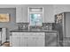 Kitchen featuring white cabinets, gray backsplash, and stainless steel appliances at 5476 Twelve Oak Ln, Conover, NC 28613