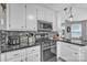 Kitchen with white cabinets, black countertops, and stainless steel appliances at 5476 Twelve Oak Ln, Conover, NC 28613