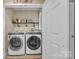 Modern laundry room with front-loading washer and dryer, shelving, and storage; offers efficient and stylish laundry convenience at 5476 Twelve Oak Ln, Conover, NC 28613