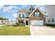 Two-story home featuring a brick and vinyl exterior, attached two-car garage, and manicured front lawn at 5580 Soft Shell Dr, Lancaster, SC 29720