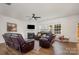 Bright living room with a fireplace, dark brown recliners, and a ceiling fan for comfort at 5580 Soft Shell Dr, Lancaster, SC 29720