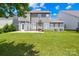Expansive backyard featuring a lush lawn and a stylish gray two-story home with a patio at 586 Brookhaven Dr, Fort Mill, SC 29708