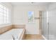 Bright bathroom features a large soaking tub with tile surround and a glass enclosed shower at 586 Brookhaven Dr, Fort Mill, SC 29708