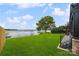 Manicured backyard leading to lake with dock and mature shade tree at 5985 Natoma Rd, Clover, SC 29710