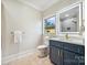 Cozy bathroom featuring modern fixtures, navy cabinets, a window, and tile floors at 5985 Natoma Rd, Clover, SC 29710