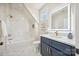 Modern bathroom with white marble tile, blue vanity, and a lighted mirror at 5985 Natoma Rd, Clover, SC 29710