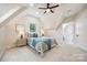 Bright bedroom with sloped ceilings, plush carpet, and an ensuite bathroom at 5985 Natoma Rd, Clover, SC 29710