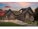 Charming stone and siding home boasts a two-car garage and manicured lawn at 5985 Natoma Rd, Clover, SC 29710