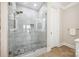 Modern shower with glass door, pebble floor, and lake views at 5985 Natoma Rd, Clover, SC 29710