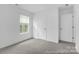 Well-lit bedroom with a window, plush carpet, and a convenient entry door at 614 Wabash Ave # 9, Charlotte, NC 28208