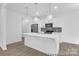 A modern kitchen island features a stainless steel sink, stainless steel appliances and pendant lighting at 614 Wabash Ave # 9, Charlotte, NC 28208