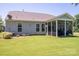 Spacious backyard featuring a screened patio with seating, a lush green lawn, and neatly landscaped surroundings at 658 Gardenbrook Trl, Belmont, NC 28012