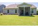 Well-maintained backyard featuring a covered patio with seating, lush green lawn, and neatly landscaped surroundings at 658 Gardenbrook Trl, Belmont, NC 28012
