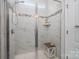 Clean and bright bathroom featuring tiled walk-in shower with glass door and a built-in toiletry shelf at 658 Gardenbrook Trl, Belmont, NC 28012