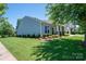 Well-maintained home showcasing a manicured lawn, covered porch with seating, and attractive landscaping for outdoor enjoyment at 658 Gardenbrook Trl, Belmont, NC 28012