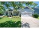 Beautifully landscaped home showcasing a two-car garage and covered porch with stone details on a sunny day at 658 Gardenbrook Trl, Belmont, NC 28012