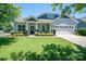 Charming home featuring a well-manicured lawn and inviting covered porch with stone accents and a two-car garage at 658 Gardenbrook Trl, Belmont, NC 28012