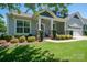 Inviting front porch featuring a covered seating area, stone accents, and lush landscaping for added curb appeal at 658 Gardenbrook Trl, Belmont, NC 28012