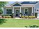 Charming front porch with stone columns, a welcoming wreath on the door, and seating for relaxing outdoors at 658 Gardenbrook Trl, Belmont, NC 28012