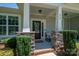 Inviting front porch with stone detailing on the columns, a welcoming wreath, and manicured landscaping at 658 Gardenbrook Trl, Belmont, NC 28012