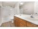 Bathroom with wooden vanity, double sinks, and tiled tub and shower at 6603 Brenock Ln, Charlotte, NC 28269
