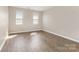 Bedroom featuring wood-look flooring and two windows that provide natural lighting at 6603 Brenock Ln, Charlotte, NC 28269