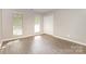 Neutral bedroom with new flooring, two windows offering natural light, and a closet for storage at 6603 Brenock Ln, Charlotte, NC 28269