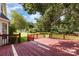 Open wooden deck with red paint and wooden railing overlooking the backyard and lawn at 6603 Brenock Ln, Charlotte, NC 28269