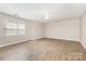 Bright living room with a ceiling fan, window, and wood-look floors at 6603 Brenock Ln, Charlotte, NC 28269