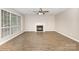 Spacious living room with vinyl floors, a cozy fireplace, and large windows offering lots of natural light at 6603 Brenock Ln, Charlotte, NC 28269