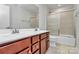 Bathroom featuring double vanity, tile flooring, and shower with glass doors at 7079 Waterwheel Sw St, Concord, NC 28025