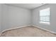 Bright carpeted bedroom with neutral tones, illuminated by a window offering ample natural light at 7079 Waterwheel Sw St, Concord, NC 28025
