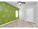 Cozy bedroom with a decorative accent wall, neutral carpet, and a bright window at 7079 Waterwheel Sw St, Concord, NC 28025