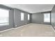 Spacious bedroom featuring neutral paint, carpet, and multiple windows at 7079 Waterwheel Sw St, Concord, NC 28025