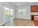 Open dining area showcasing wood floors, sliding glass doors, and a view into the kitchen at 7079 Waterwheel Sw St, Concord, NC 28025