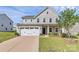 Charming two-story home featuring a two-car garage and a well-manicured front yard at 7079 Waterwheel Sw St, Concord, NC 28025